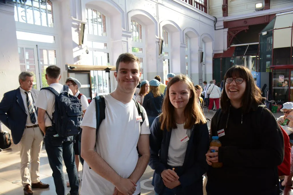 Un groupe de jeunes hospitaliers en gare, prêts pour le départ
