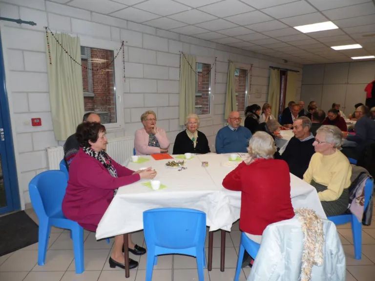Pèlerins et bénévoles réunis autour de tables pour un repas convivial