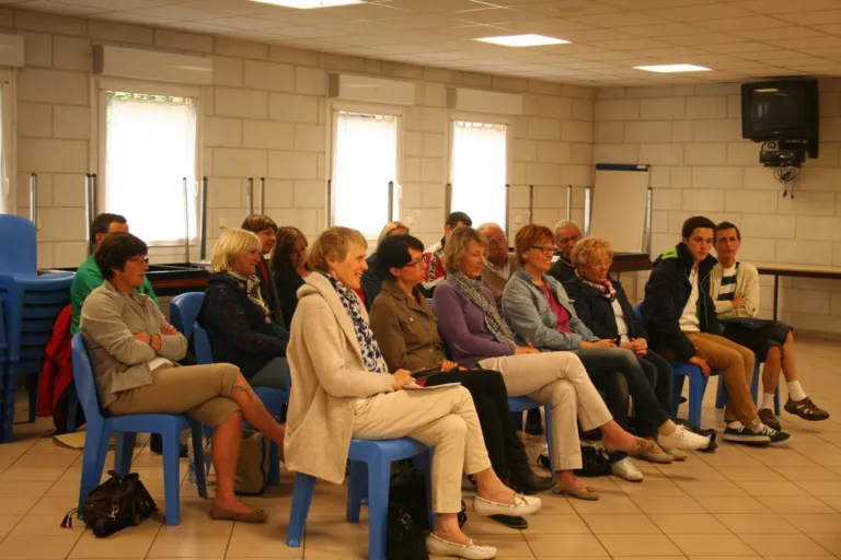 Réunion d'information : des personnes assises écoutent dans une salle